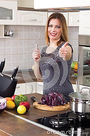 Modern housewife prepare a meal and shows a thumbs up