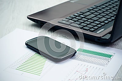 Modern laptop and smart phone on wooden desk.