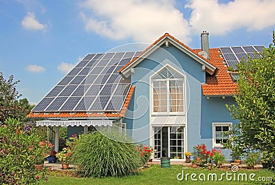 Modern new built house and garden, rooftop with solar cells, blu