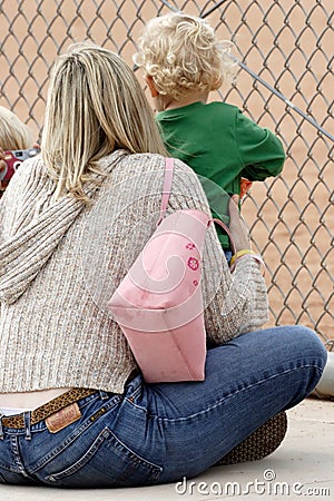 Mom and Baby watching baseball game on sidelines