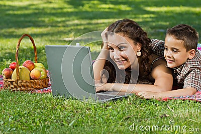 Mom and child with laptop outdoors