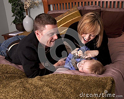 Mom and Dad tickling Son