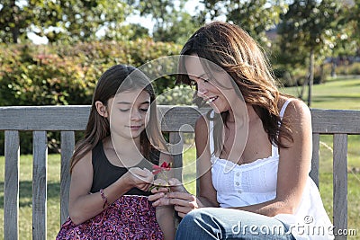 Mom and daughter looking at flower