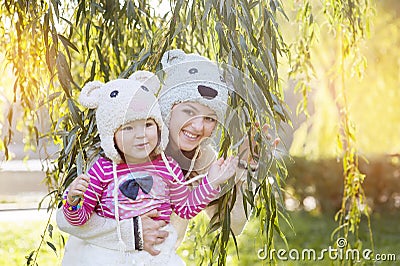 Mom and daughter in the park, in a knitted hat smiling