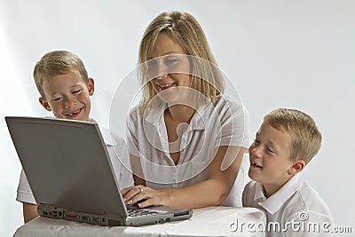 A Mom teaching 6 years olds how to use a laptop