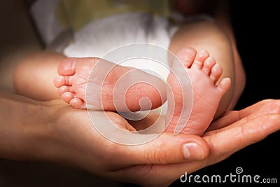 Moms hands holding baby s feet