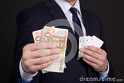 Money and four aces cards in mans hands