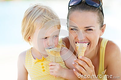 Mother and baby biting ice cream