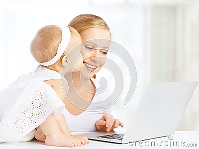 Mother and baby at home using laptop computer
