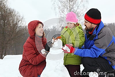 Mother and dad with daughter sculpt snowman