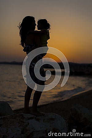 Mother and daughter at the beach at sunset