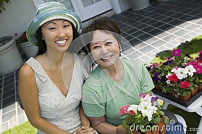 Mother and daughter with flowers smiling (portrait)