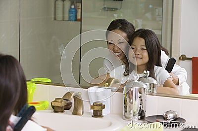 Mother and Daughter Looking at reflection mirror