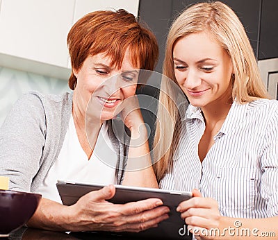 Mother and daughter looking in tablet pc
