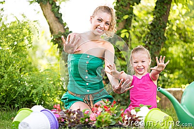 Mother and daughter planting flowers together