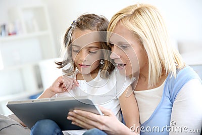 Mom with little girl using tablet