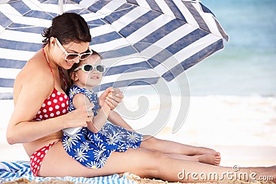 Mother And Daughter Putting On Sun Cream