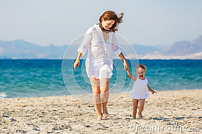 Mother and daughter running on the beach