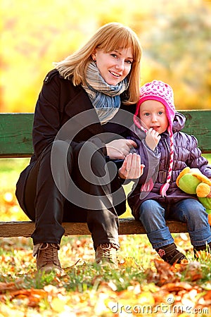 Mother and daughter sitting on a bench in the park
