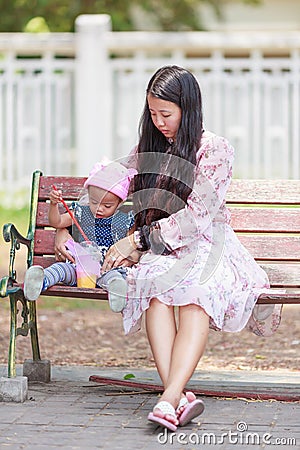 Mother and daughter sitting in park