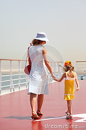 Mother and daughter walking on cruise liner deck