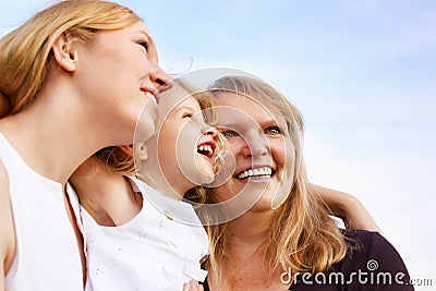 Mother, grandmother and little girl looking up
