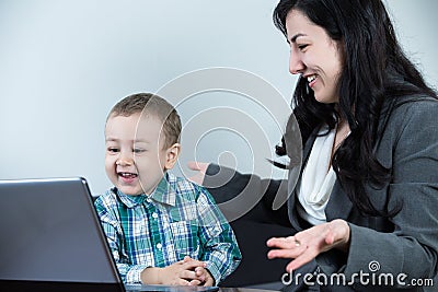 Mother having a great time with her boy while looking at the computer