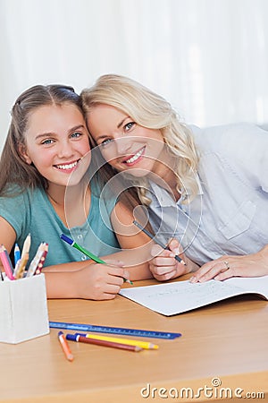 Mother helping daughter with homework in living room