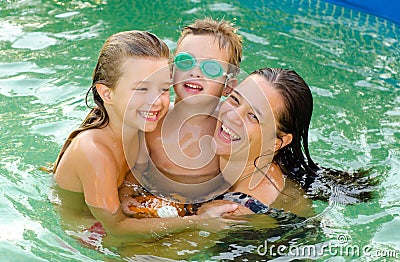 Mother and her children in the swiming pool