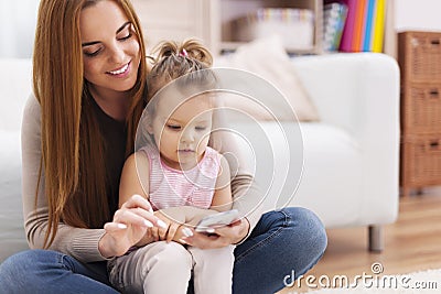 Mother with her daughter using smart phone