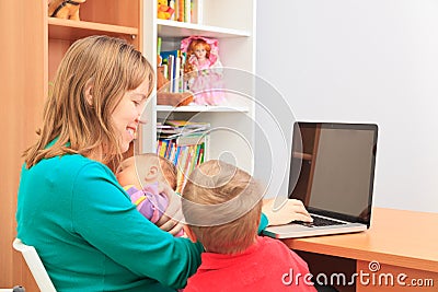 Mother with kids working on laptop at home
