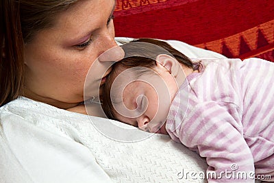 Mother kissing baby asleep