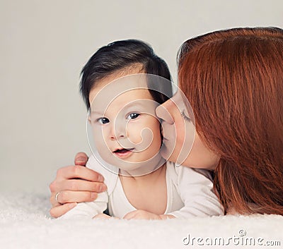 Mother kissing her little newborn baby