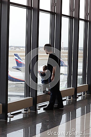 Mother with son looking at airplane