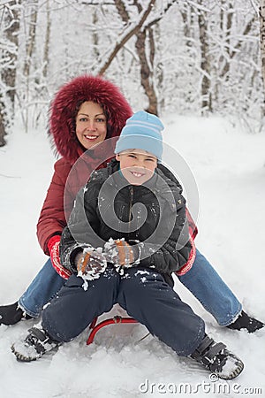 Mother, son ride on sled