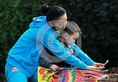 Mother and son taking a photo by themselves in a park,in chengdu,china