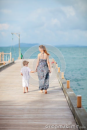 Mother and son walking along jetty