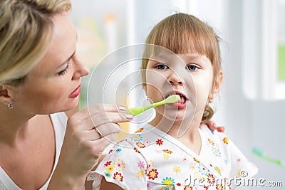 Mother teaches kid teeth brushing