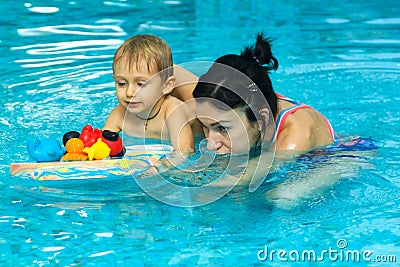 Mother teaching baby boy to swim