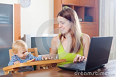 Mother working with laptop and baby