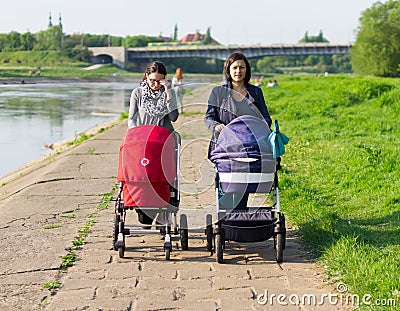 Mothers walk next to river