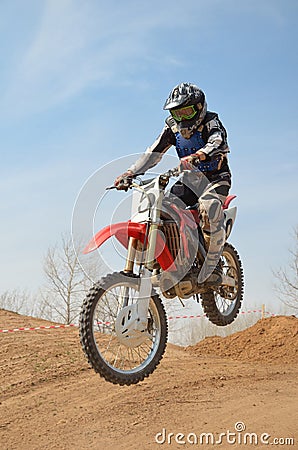 Motocross motorbike racer performs a jump