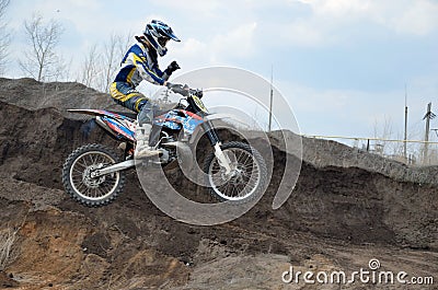Motocross rider jumps over an earthen pit