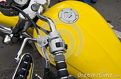 Motorcycle wheel and yellow petrol tank details.