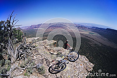 Mountain Biker On Rock Looking At View