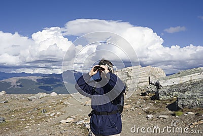 Mountain hiker looking through binoculars