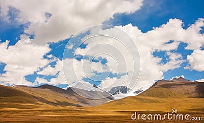 Mountain range on a sunny day is covered with clean white clouds