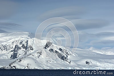 Mountains of western Antarctic Peninsula in cloudy day.