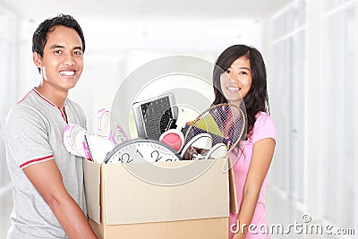 Moving day. couple with their stuff inside the cardboard box