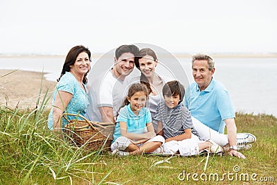 Multi Generation Family Having Picnic By Sea